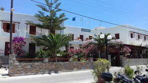 A building with a sign reading "MAISTRALI" and balconies with railings.