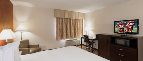 A hotel room with a bed, two bedside lamps, a desk with a chair, a television, and a wardrobe.