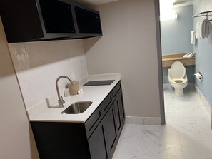 Un baño pequeño con lavamanos, inodoro y una pequeña encimera.