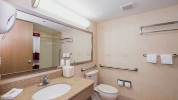 Un baño con lavamanos, inodoro y espejo.