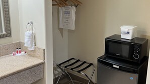 A compact kitchenette with a microwave, a small refrigerator, a towel rack, and a drying rack. - Travelodge by Wyndham Brea (Brea)