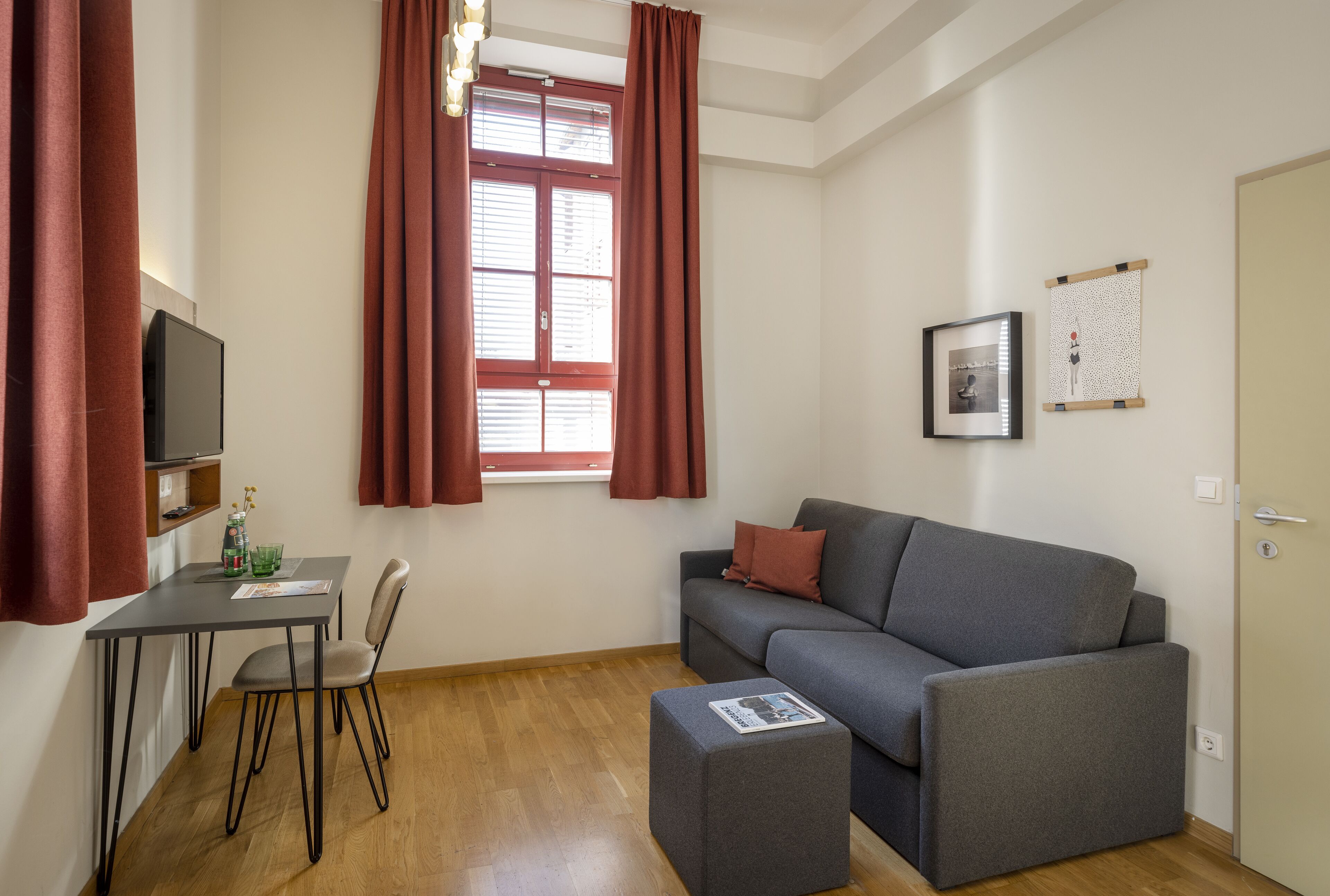A modern living room with a grey sofa, a small table, and a TV.
