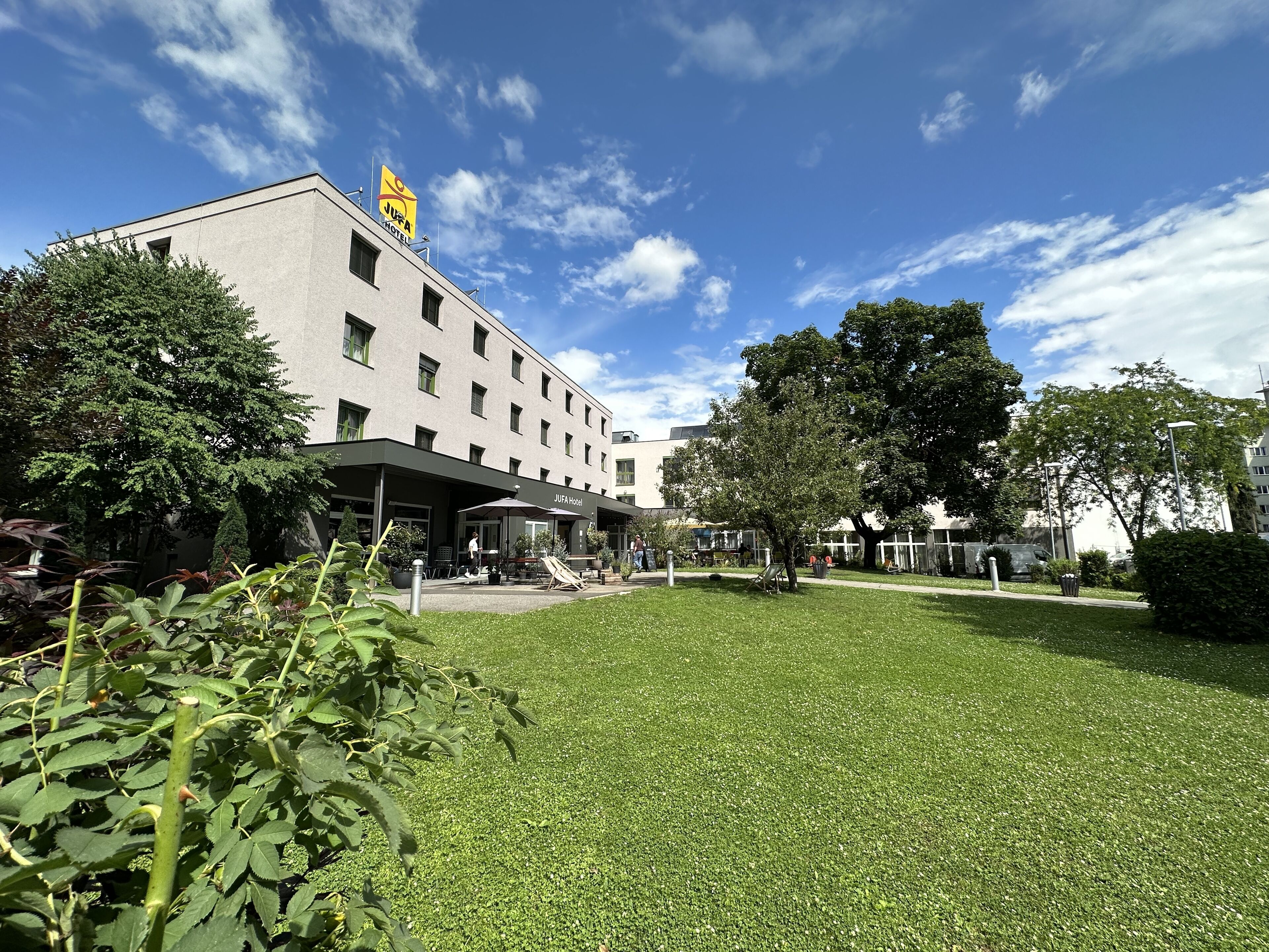A hotel with a flat roof, multiple windows, and a signboard.