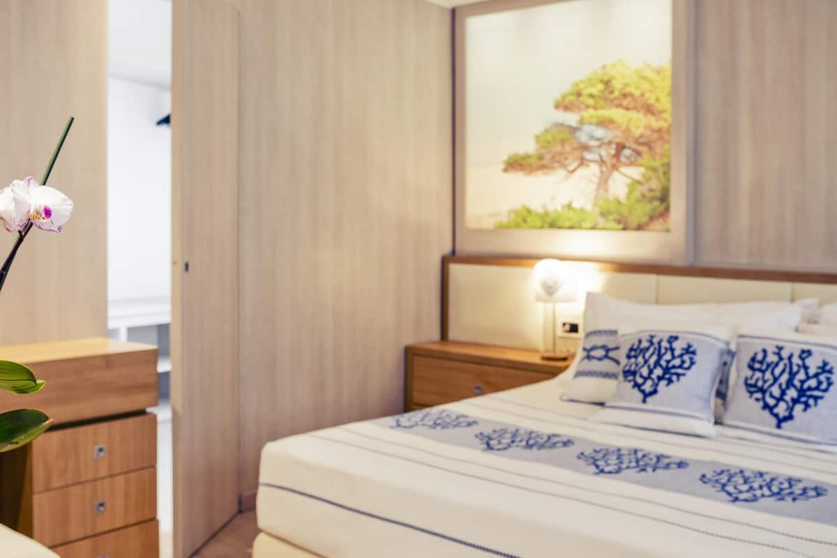 Une chambre à coucher avec un lit, une table de chevet et une commode.