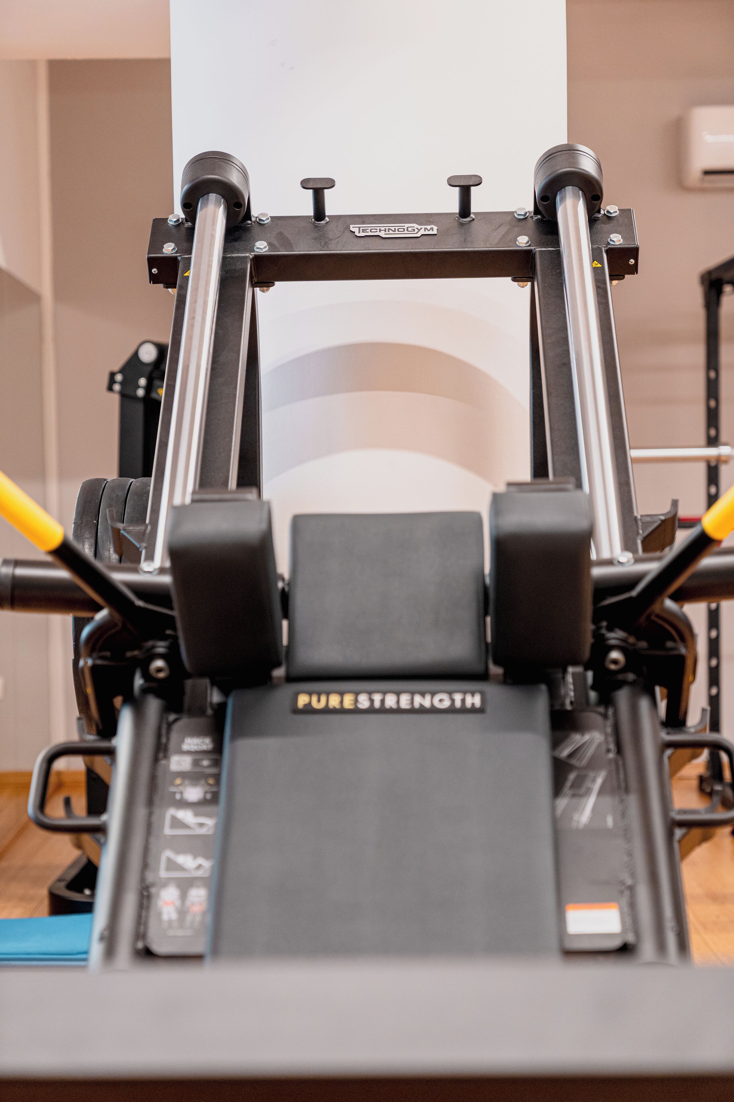 A piece of exercise equipment labeled "PURESTRENGTH" in a gym setting.