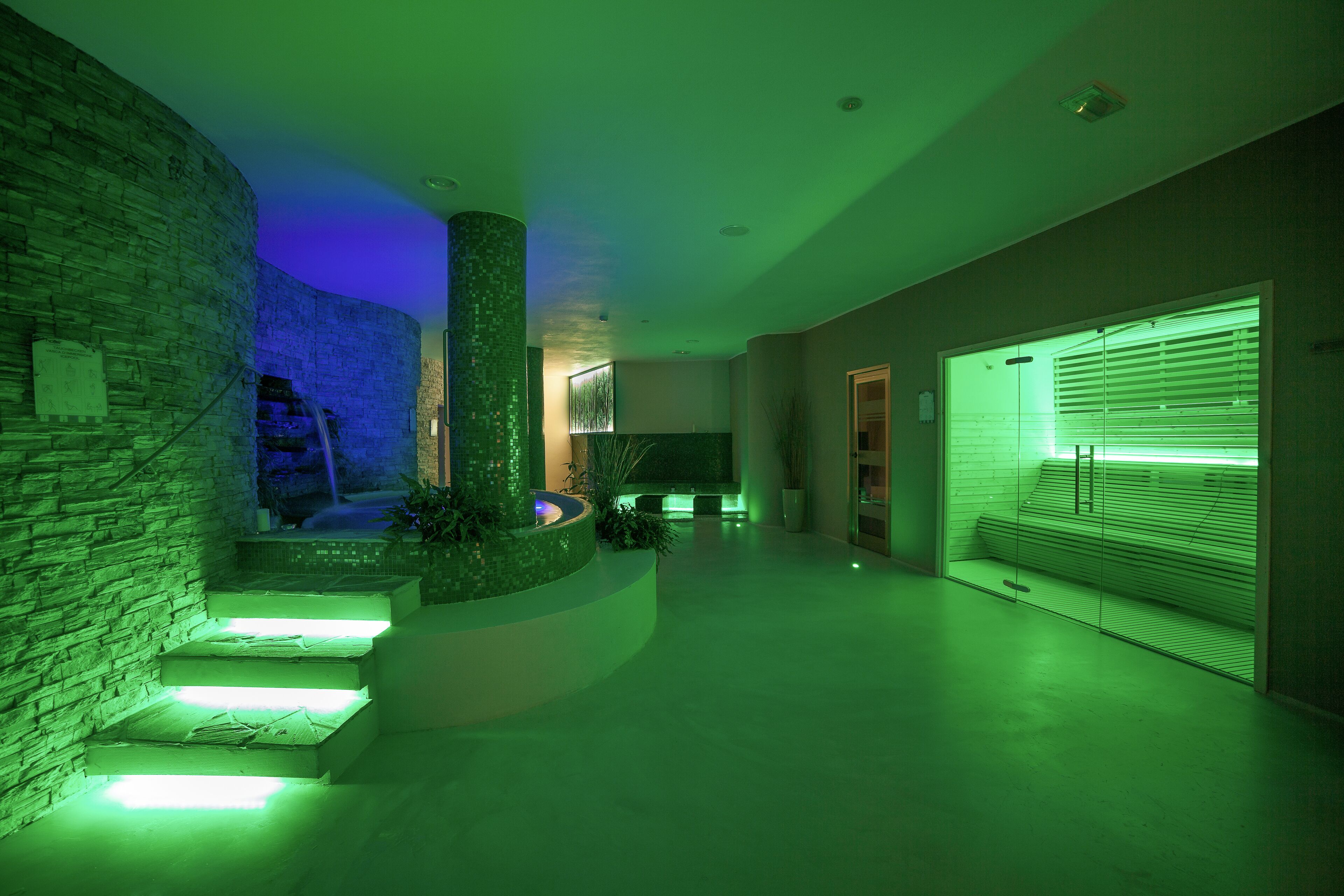 A modern interior with a stone wall, a curved staircase, and a glass partition.