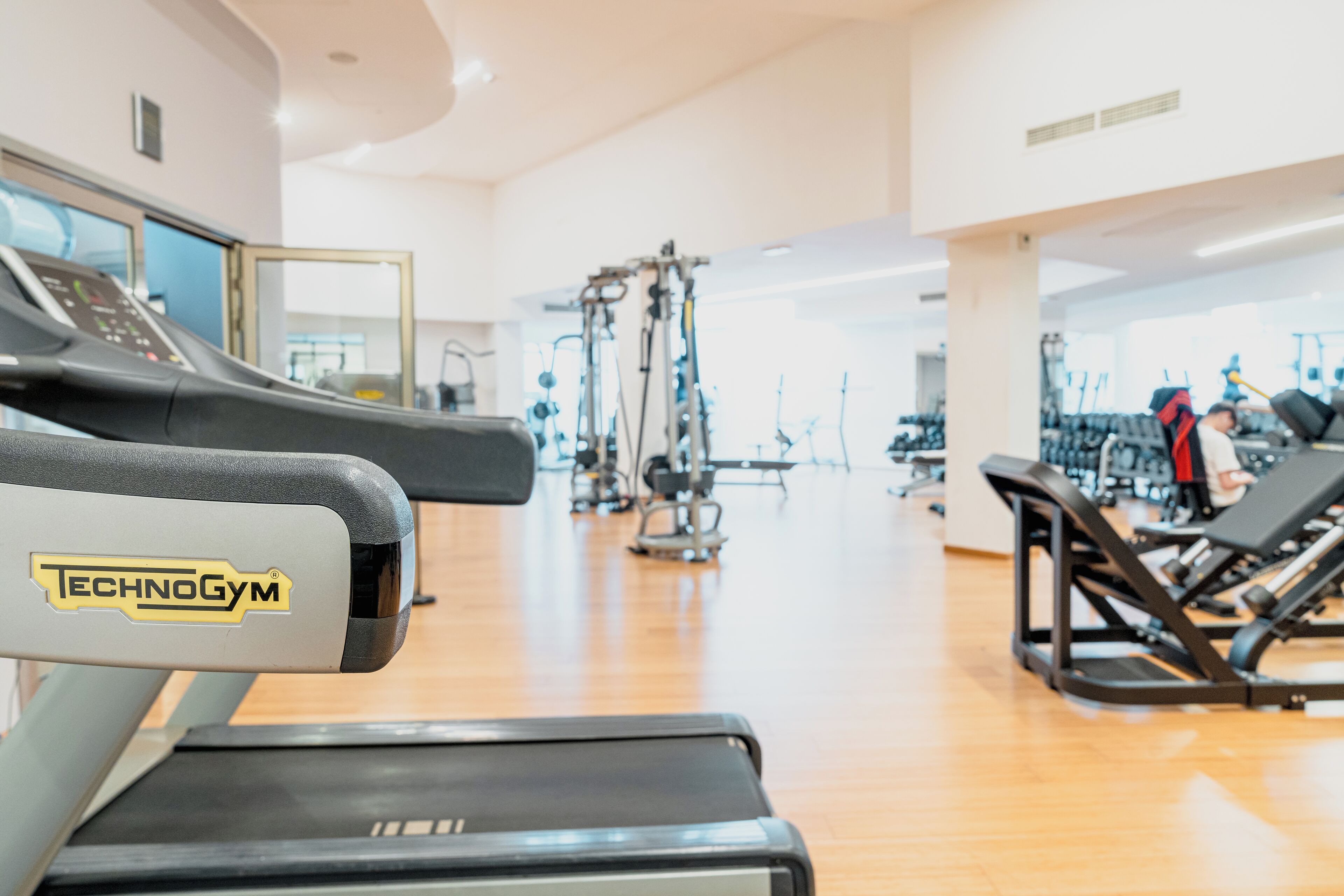 A gym with a treadmill, weight machines, and exercise equipment.