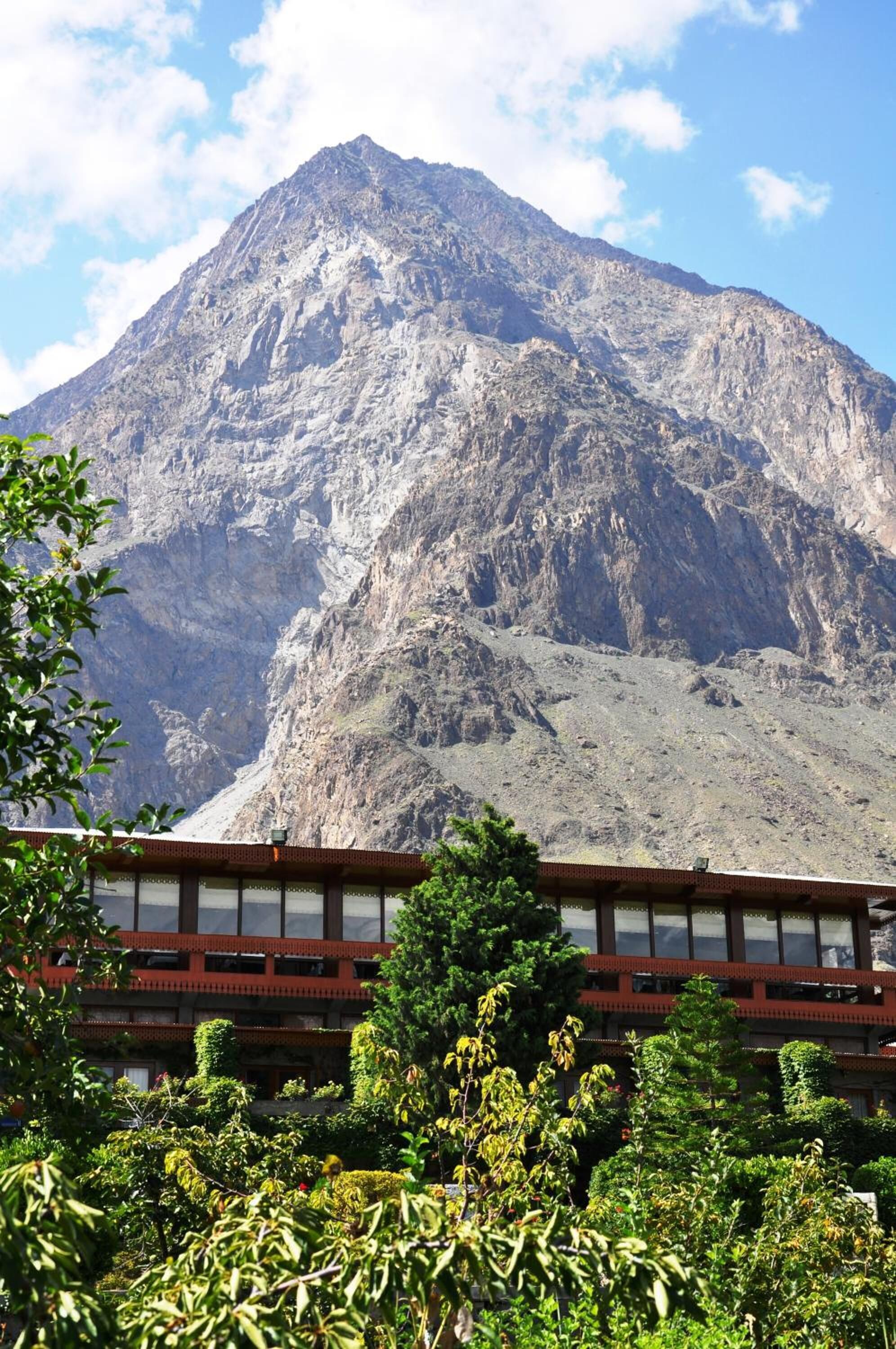 A building with a traditional architectural style, featuring a prominent mountain in the background.