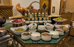 A buffet with various dishes and bowls of food.