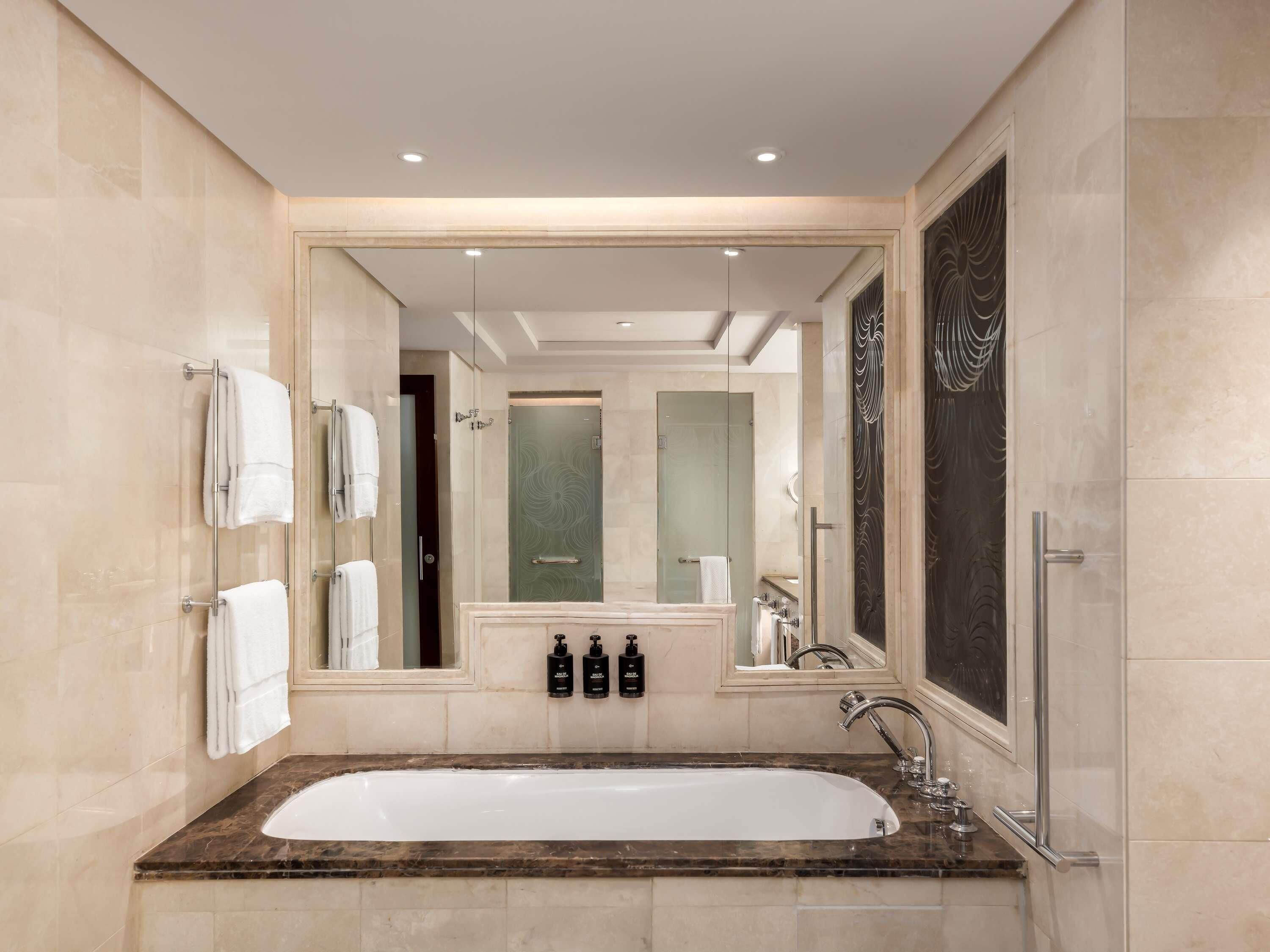Une salle de bain moderne avec une grande baignoire, une douche en verre et un meuble-lavabo avec un miroir.