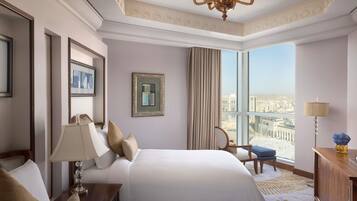Habitación de hotel con dos camas, un candelabro, obras de arte enmarcadas, vista a la ciudad y un ventanal grande.
