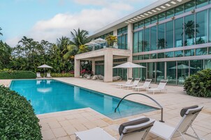 Una piscina al aire libre, sillones reclinables de piscina