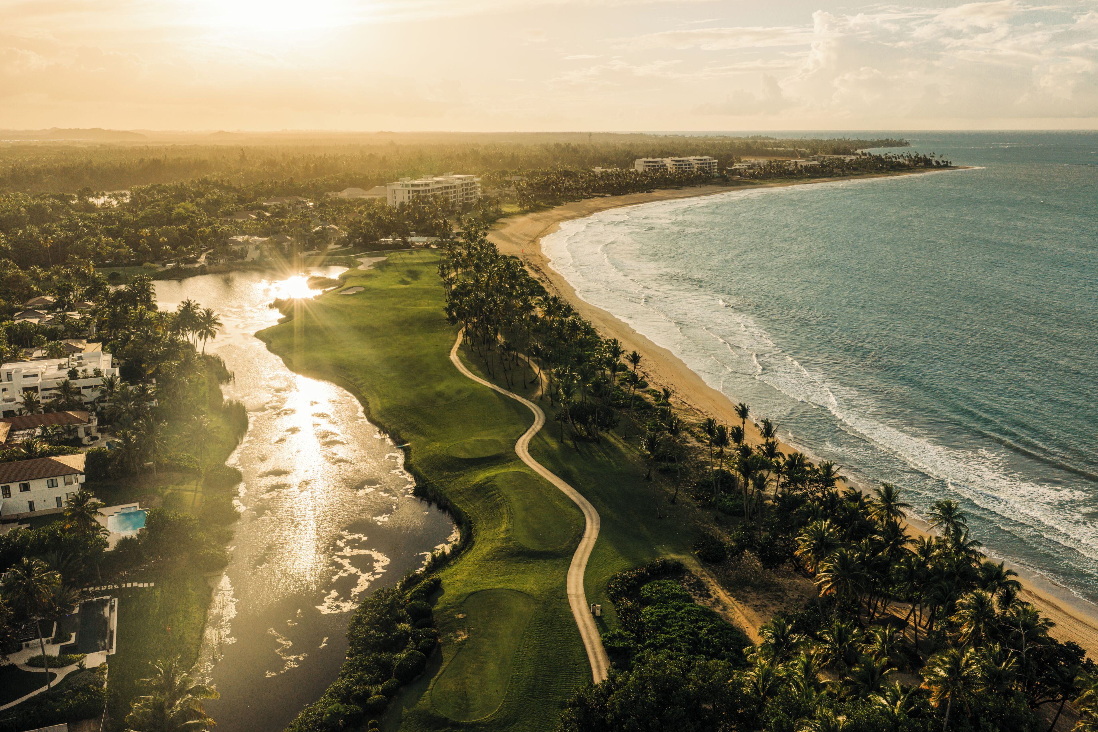 Un complejo turístico frente al mar con campo de golf y piscina.