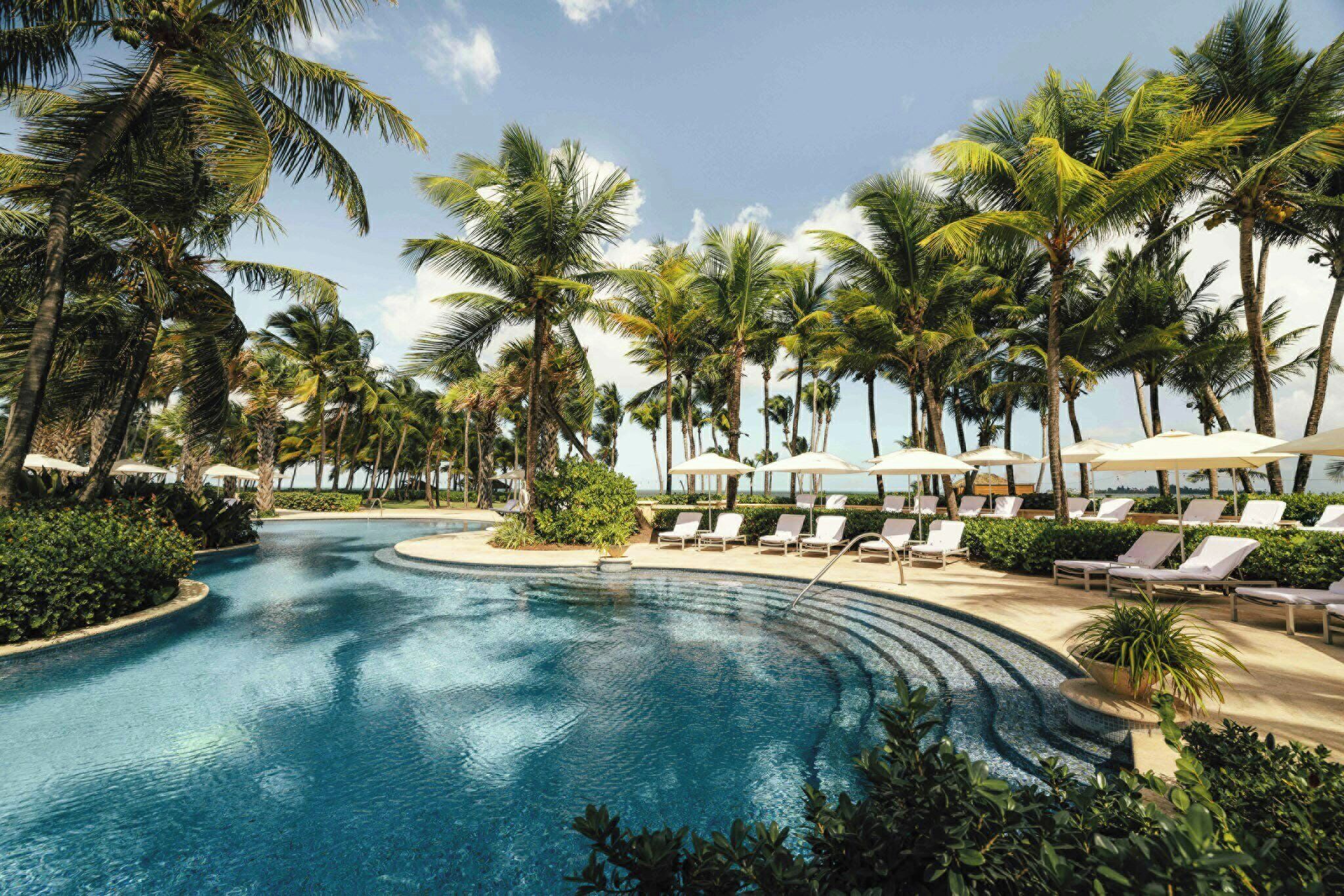 Una piscina al aire libre, sillones reclinables de piscina