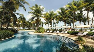 Una piscina al aire libre, sillones reclinables de piscina