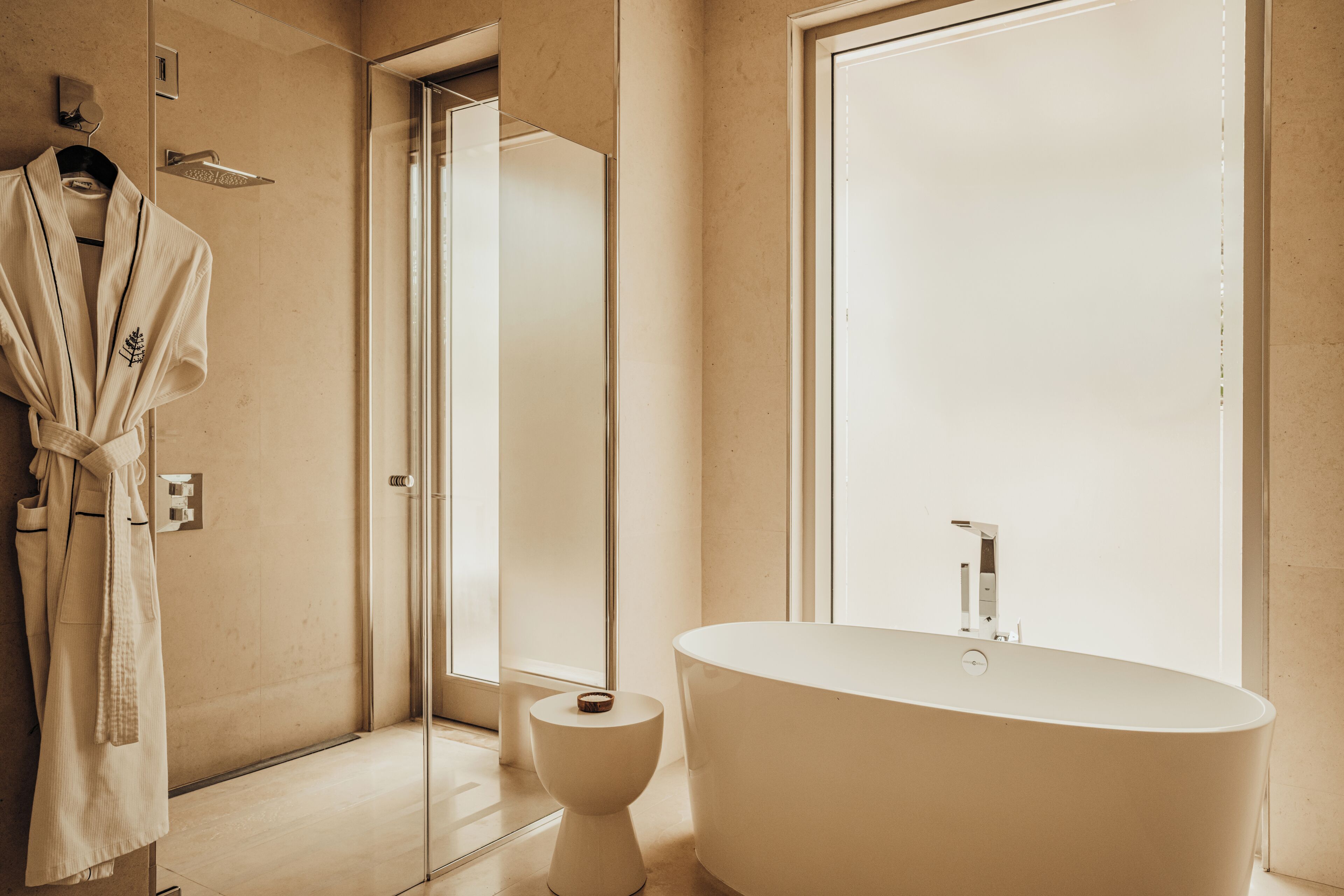 A modern bathroom with a freestanding bathtub, a glass shower enclosure, and a toilet.