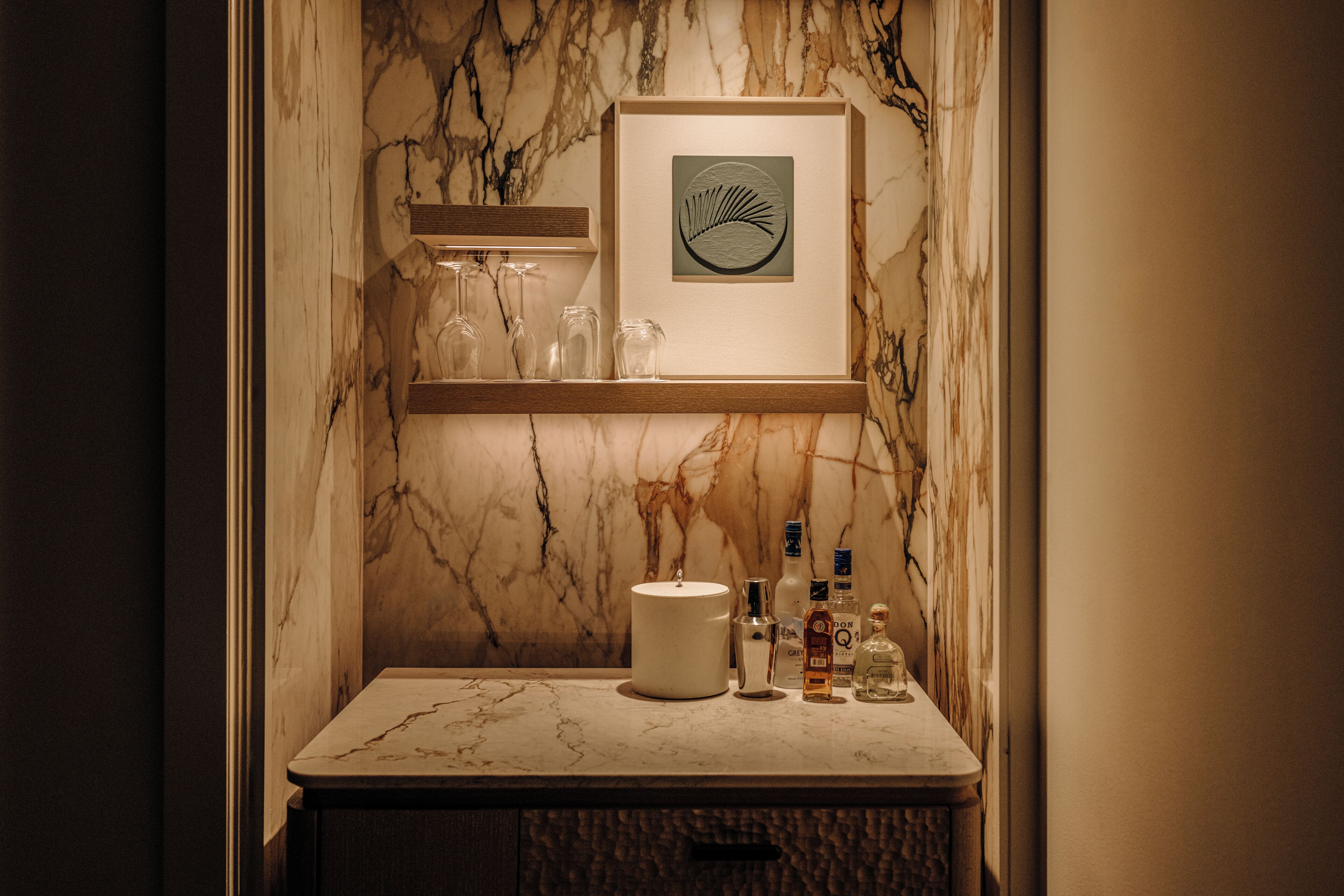 A marble bathroom vanity with a framed artwork, a sink, and a cabinet.