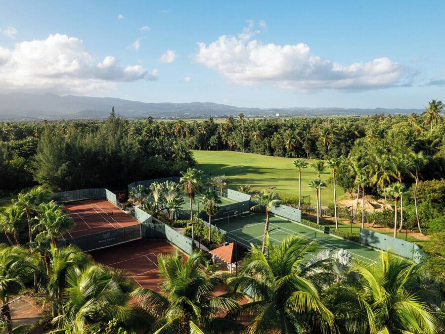 A golf course with a view of distant mountains and palm trees.