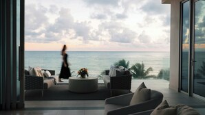 A modern living room with a view of the ocean, furnished with sofas and a coffee table. - Four Seasons Resort and Residences Puerto Rico (Río Grande)