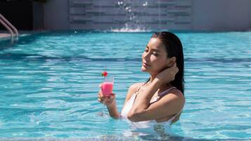 Una piscina al aire libre, sillones reclinables de piscina