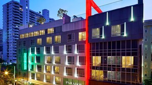 A modern hotel with a prominent red structural element, multiple floors, and a visible restaurant named "Paradox" on the ground floor. - Paradox Bangkok Sukhumvit (Bangkok)
