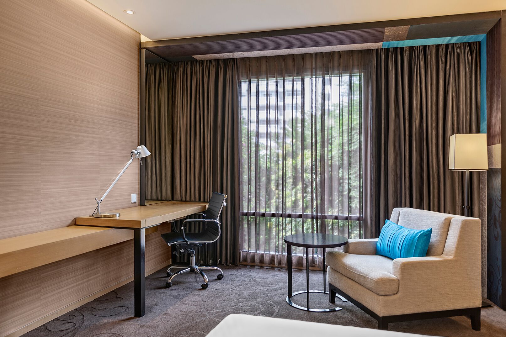 Una habitación de hotel con escritorio, silla y sofá.