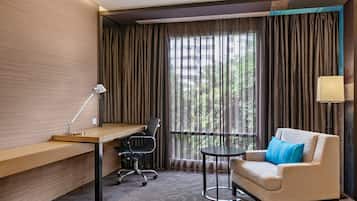 Una habitación de hotel con escritorio, silla y sofá.