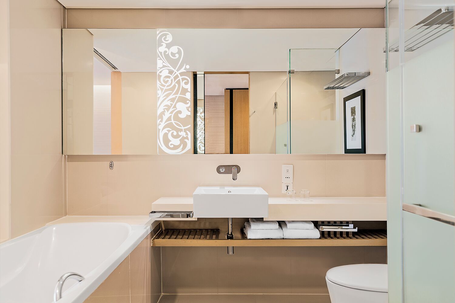 A modern bathroom with a bathtub, sink, and toilet.