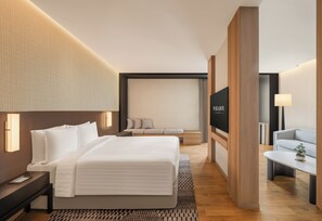 A modern hotel room with a large bed, a sofa, a TV, and a desk. - Paradox Bangkok Sukhumvit (Bangkok)