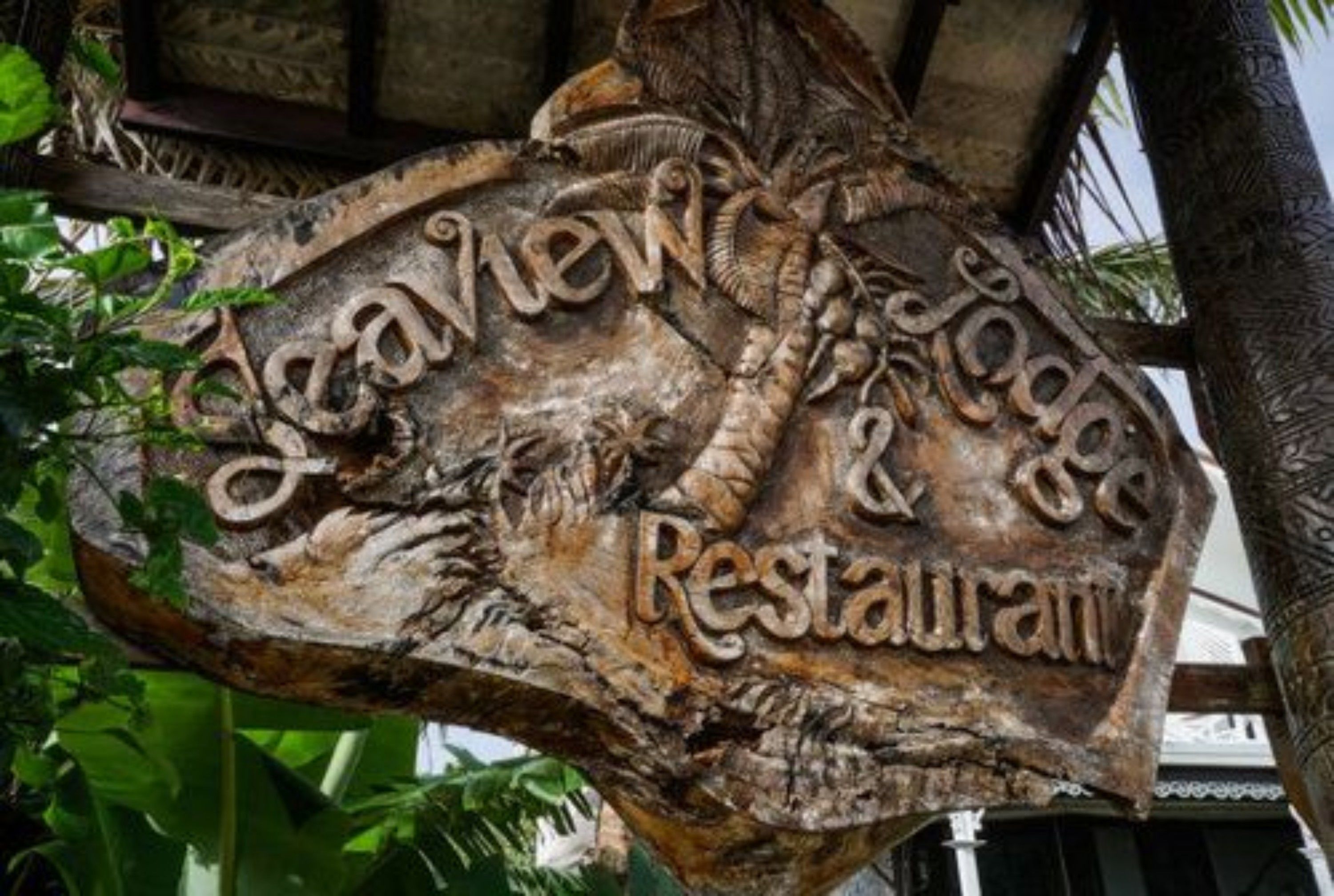 A carved wooden sign for a restaurant with the name 'Beachview Lodge & Restaurant'.