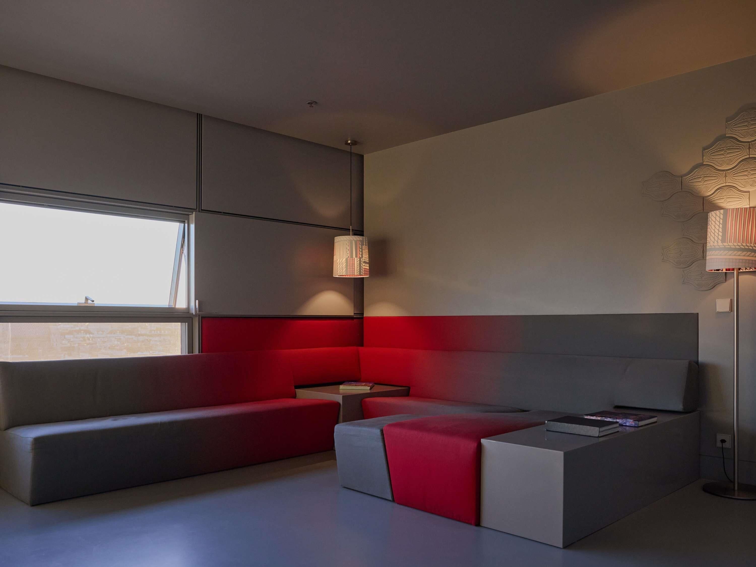 A modern room with a sofa, a small table, and a lamp.