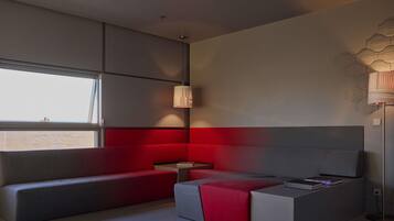 A modern room with a sofa, a small table, and a lamp.