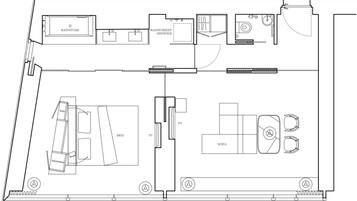 Ein Beispielgrundriss eines Zimmers mit Badewanne, begehbarer Dusche, Bett, Fernseher, Sofa und Fenstern.