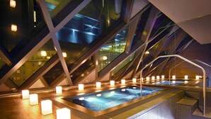 A modern indoor pool with geometric glass railings and illuminated cubical lights. - SO/ Vienna (Vienna)