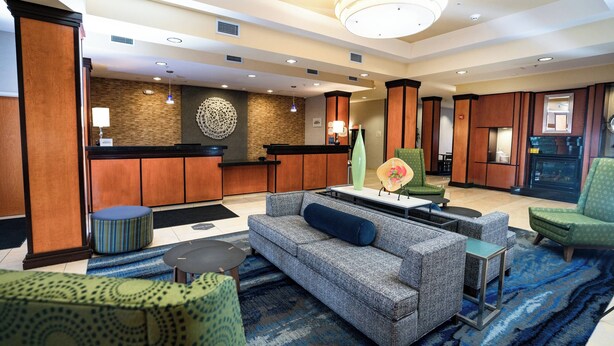 A lobby with a reception desk, seating area, and a fireplace.
