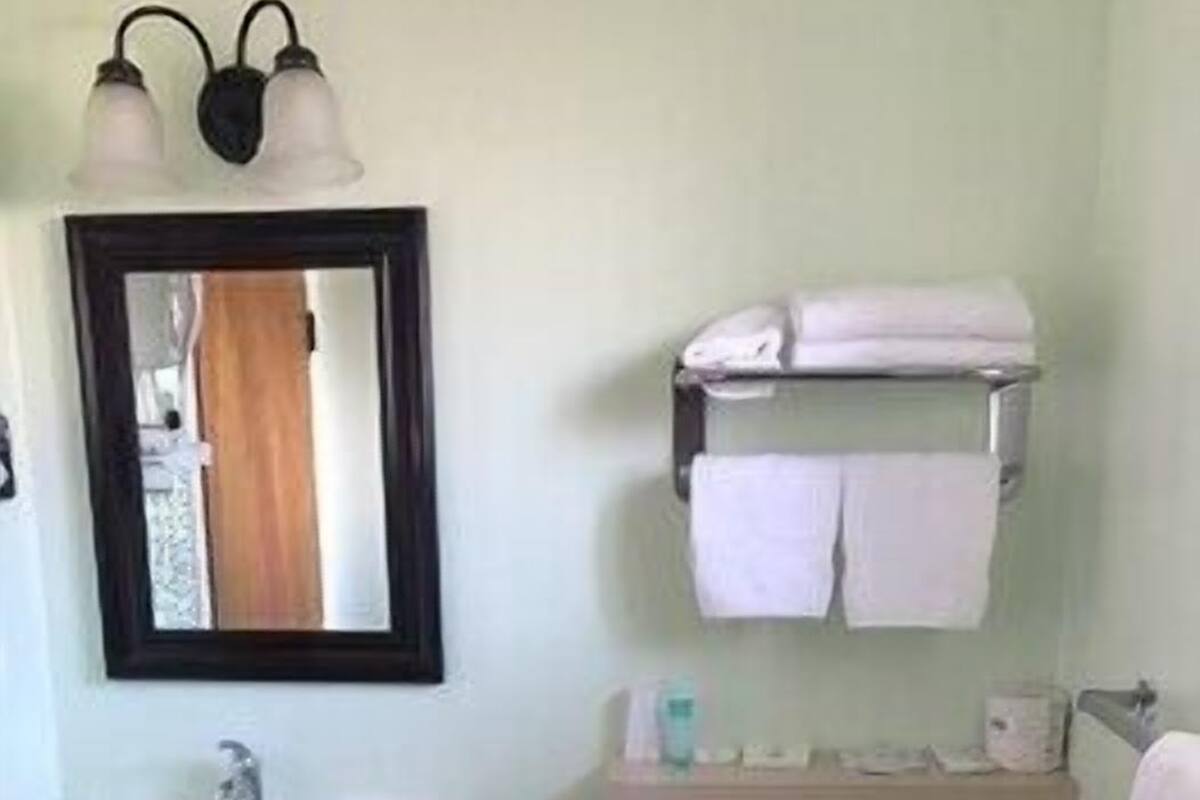 A bathroom with a sink, toilet, and a mirror above the sink.