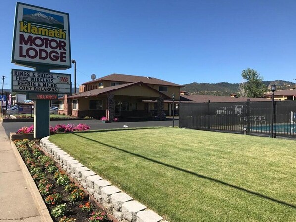 Een motel met een bord waarop faciliteiten staan aangeboden, zoals gratis wifi, een koelkast en een continentaal ontbijt.