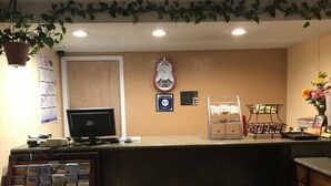 Una recepción con un monitor de computadora, un reloj y una máquina de café.