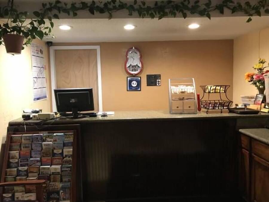 A reception desk with a computer monitor, a clock, and a coffee machine.