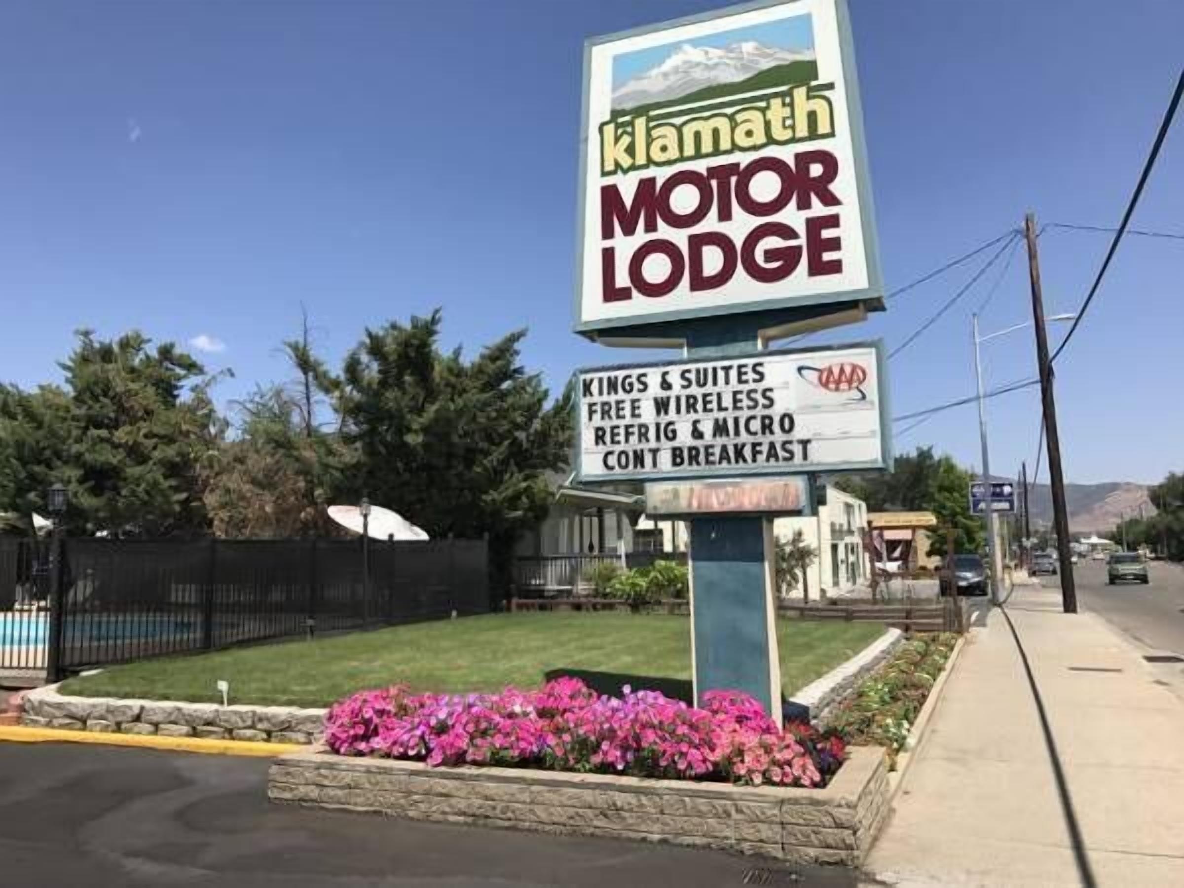 A sign for Klamath Motor Lodge advertising amenities like kings & suites, free wireless, and breakfast.