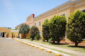 A hotel with a paved courtyard, potted plants, and a clear sky. - Hotel ZAR Guadalajara (Zapopan)