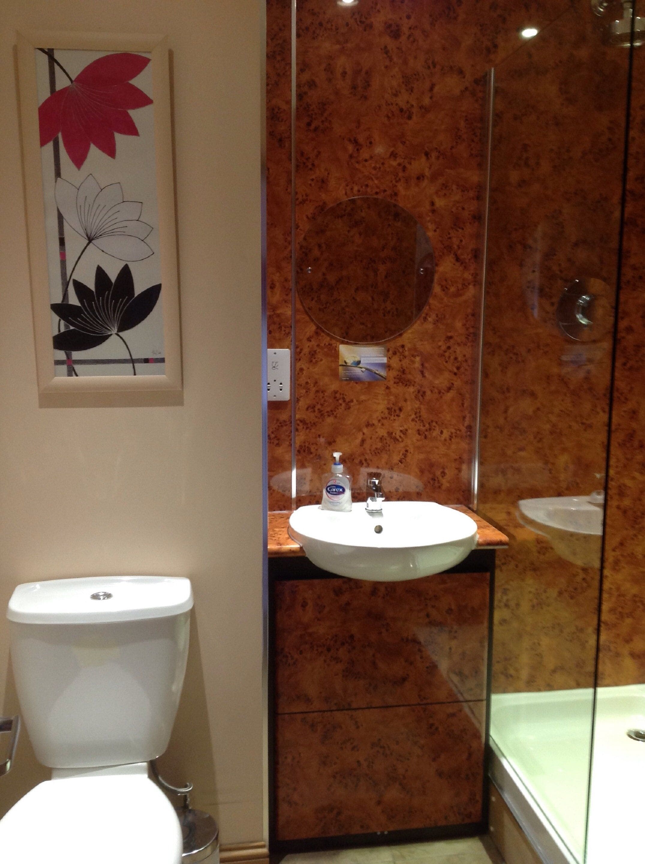 Un baño con inodoro, lavabo y cabina de ducha con paredes de vidrio.