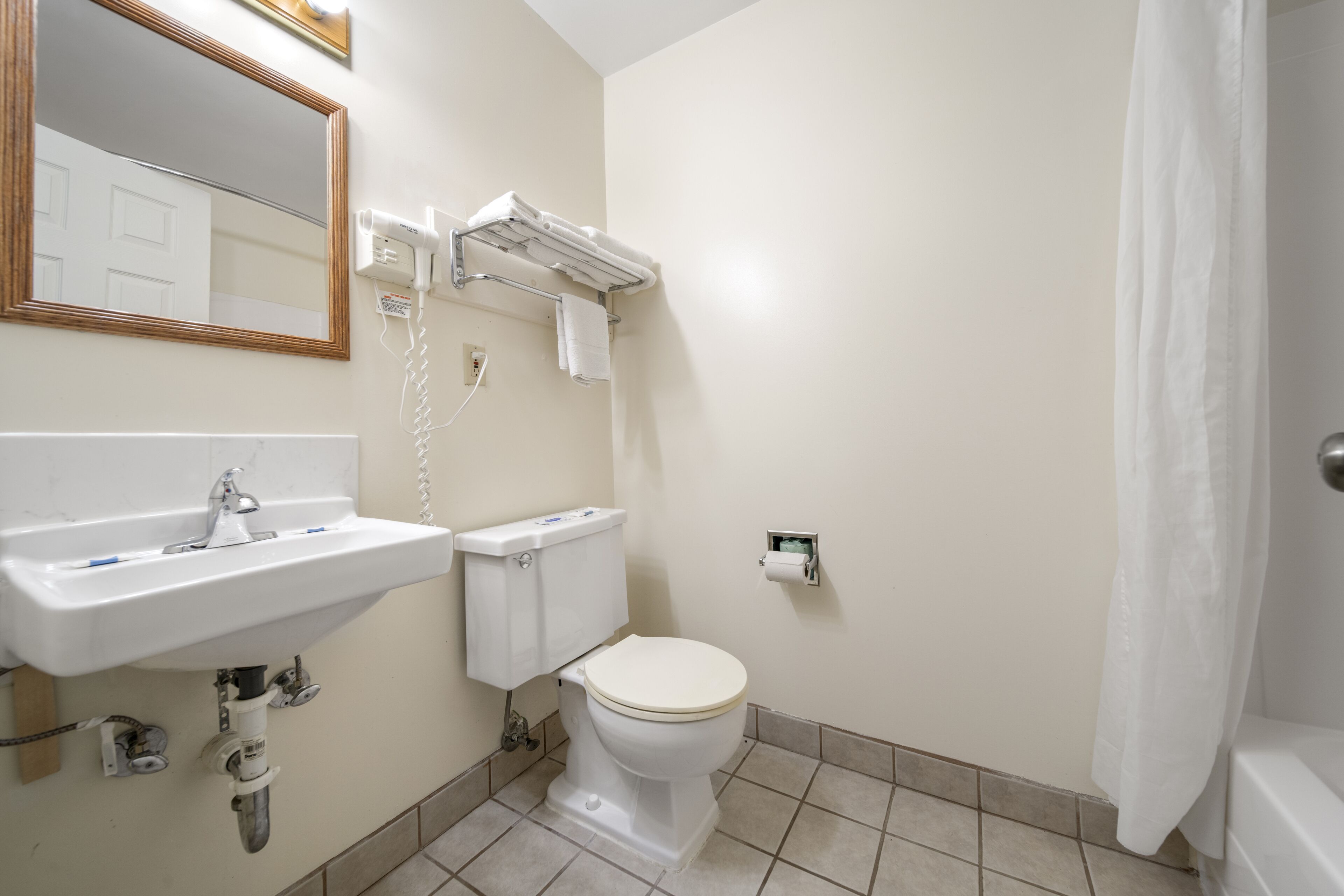 Un baño con lavabo, inodoro y cortina de ducha.