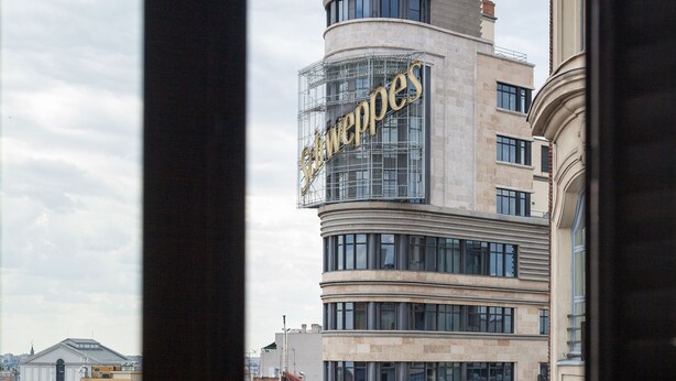 A multi-story building with a Vodafone sign, a curved facade, and a view of the surrounding cityscape. - Hostal Josefina (Madrid)
