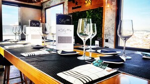 A restaurant table set with wine glasses, plates, and cutlery, with a menu titled "Sky 44" and a sign reading "Sky 44" on the wall. - Hostal Josefina (Madrid)