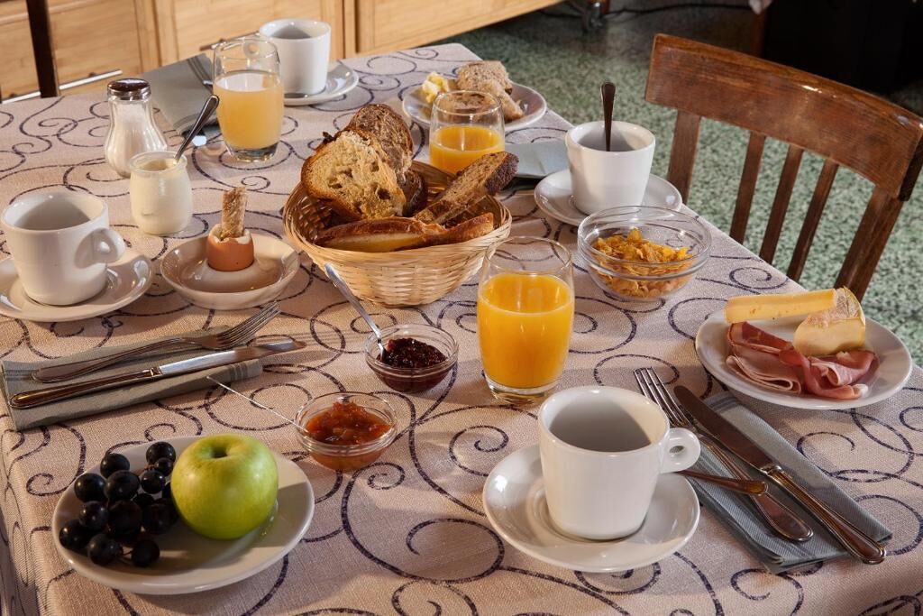 Taula de petit esmorzar amb pa, fruita, formatge i cafè.
