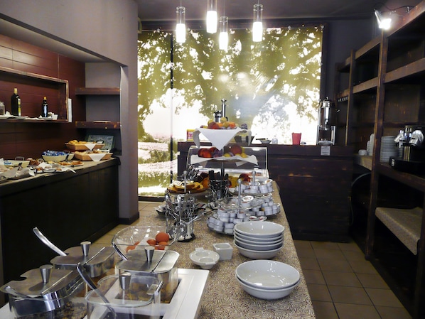 Un buffet proposant une variété de plats et d’ustensiles de service.