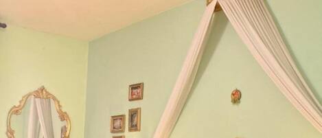 Une chambre à coucher comprenant un lit, une table de chevet, une commode, un miroir et un ventilateur de plafond.