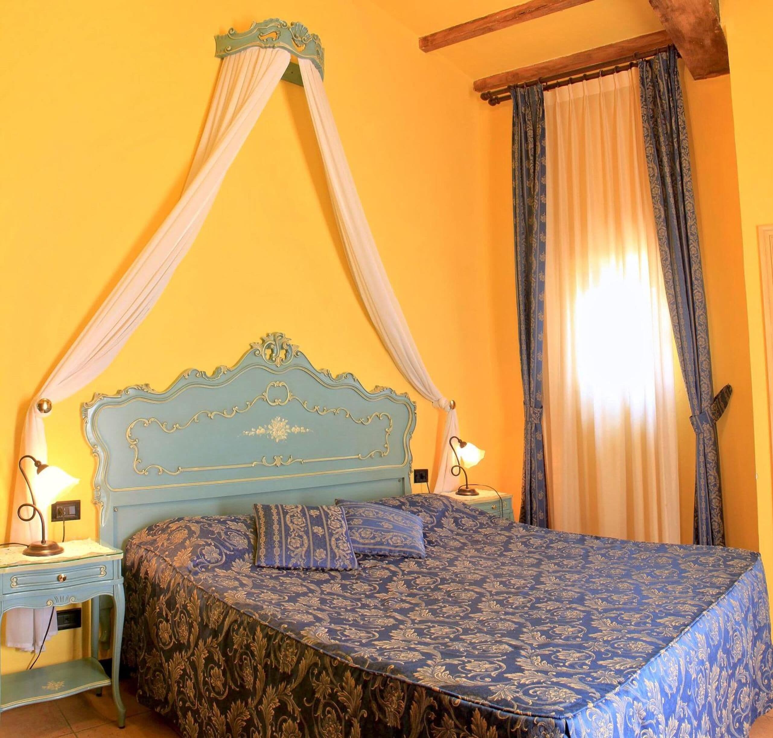Quarto com cama de dossel, duas mesas de cabeceira e um dossel.