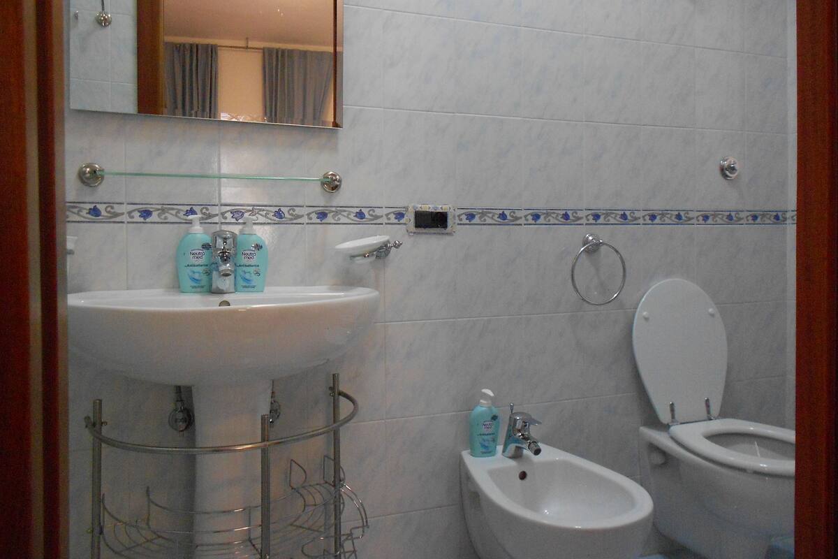 A bathroom with a sink, bidet, and toilet.